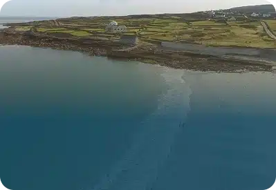 Stone-walled fields rising from the harbour